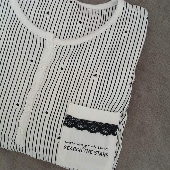 Robe de nuit Étoile Noir 🌛
Robe de nuit élégante à rayures fines et motifs étoiles, avec col boutonné et poche décorée de dentelle noire.
Matière douce et légère, idéale pour des nuits confortables avec une touche chic. – Image 2